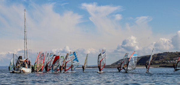 a racing startline with a yacht as the committee boat